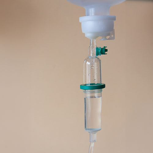 Medizinisches Personal in OP-Kleidung legt ein grünes steriles Abdecktuch mit einer Öffnung über einen Patienten